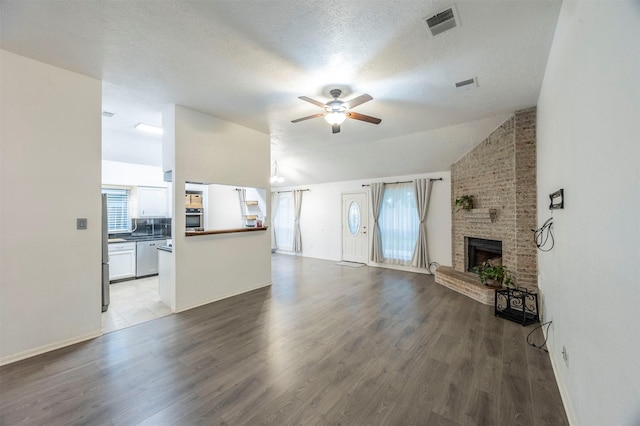 8526 Greenleaf Lake Dr, Houston, TX 77095 - unfurnished living room featuring a ceiling fan, wood finished floors, a brick fireplace, healthy amount of natural light, and lofted ceiling