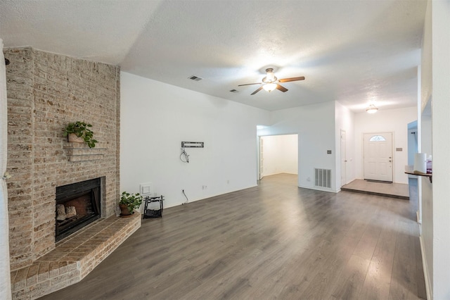 8526 Greenleaf Lake Dr, Houston, TX 77095 - unfurnished living room featuring a ceiling fan, wood finished floors, a fireplace, and a textured ceiling