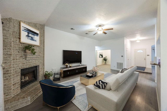 8526 Greenleaf Lake Dr, Houston, TX 77095 - living area featuring a ceiling fan, a brick fireplace, wood finished floors, and a textured ceiling