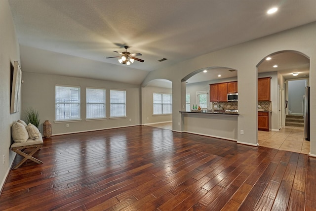 59 Pleasant Point Pl, Spring, TX 77389 - unfurnished living room with arched walkways, a ceiling fan, light wood-style flooring, recessed lighting, and vaulted ceiling