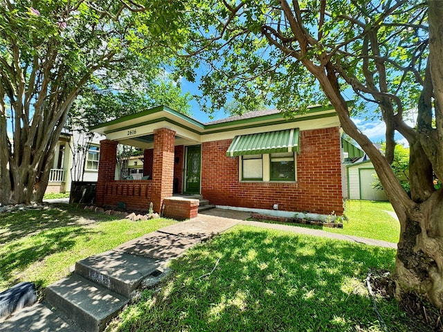 2616 Beauchamp St, Houston, TX 77009 - view of front of home featuring brick siding, a front yard, and a porch