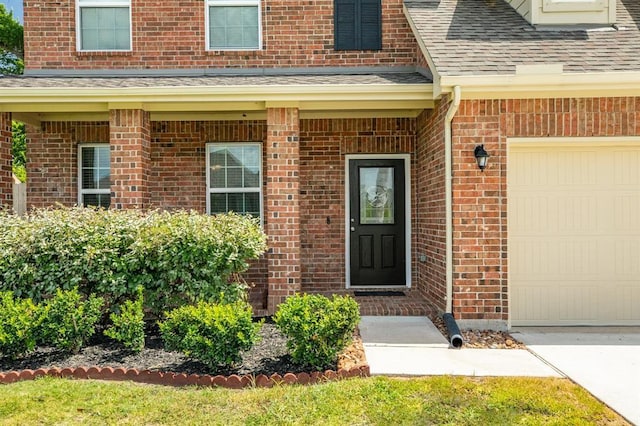 511 Moore St, Richwood, TX 77531 - doorway to property with brick siding, a shingled roof, concrete driveway, and a garage