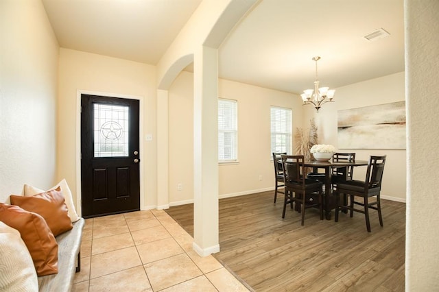 511 Moore St, Richwood, TX 77531 - entryway featuring arched walkways, a chandelier, healthy amount of natural light, and light wood-type flooring