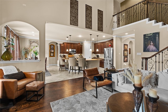 1509 Preserve Ln, Pearland, TX 77089 - living area featuring arched walkways, stairway, parquet floors, a towering ceiling, and crown molding