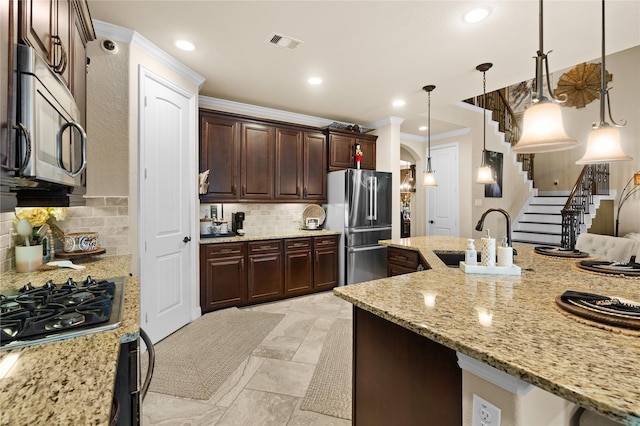 1509 Preserve Ln, Pearland, TX 77089 - kitchen featuring stainless steel appliances, ornamental molding, tasteful backsplash, hanging light fixtures, and light stone counters