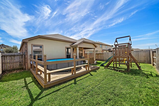 22526 Belmont Cove Ln, Katy, TX 77449 - rear view of house featuring a fenced backyard, a wooden deck, a playground, and ceiling fan