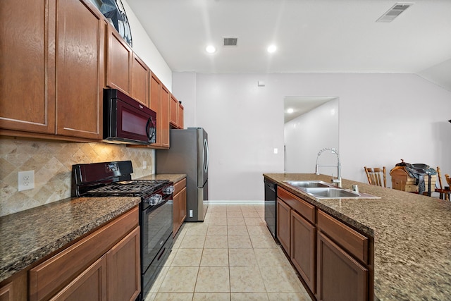 22526 Belmont Cove Ln, Katy, TX 77449 - kitchen featuring black appliances, tasteful backsplash, light tile patterned flooring, vaulted ceiling, and brown cabinetry