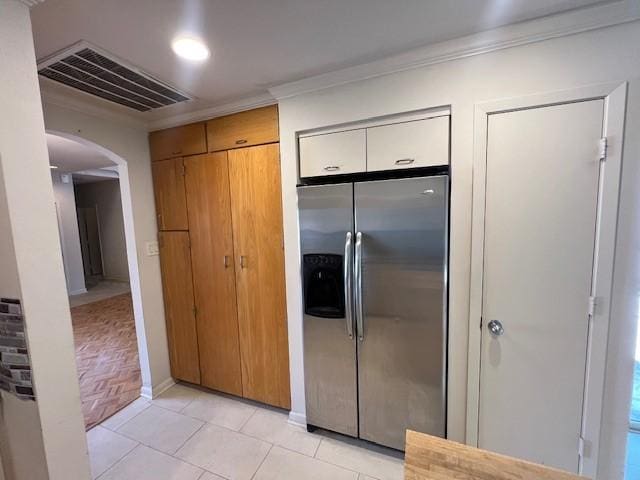 7655 S Braeswood Blvd Unit 8, Houston, TX 77071 - kitchen with stainless steel fridge with ice dispenser, arched walkways, ornamental molding, and light tile patterned flooring