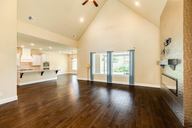 10306 Terra St, Iowa Colony, TX 77583 - unfurnished living room with a stone fireplace, ceiling fan, dark wood-type flooring, and high vaulted ceiling