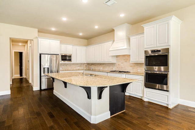 10306 Terra St, Iowa Colony, TX 77583 - kitchen with appliances with stainless steel finishes, decorative backsplash, dark wood-style flooring, an island with sink, and recessed lighting