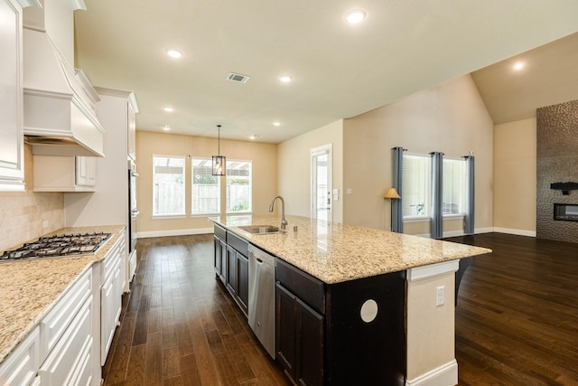 10306 Terra St, Iowa Colony, TX 77583 - kitchen featuring dark wood finished floors, stainless steel appliances, custom range hood, white cabinetry, and light stone counters