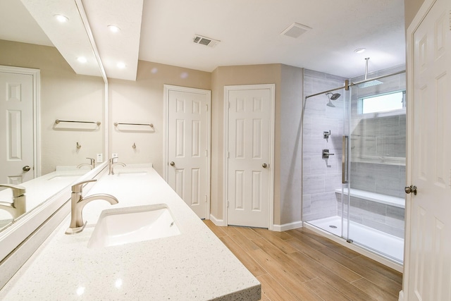 7602 12th Fairway Ln, Humble, TX 77346 - bathroom featuring a stall shower, double vanity, recessed lighting, and wood finished floors