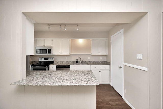 6307 Briar Rose Dr Unit 120, Houston, TX 77057 - kitchen with stainless steel appliances, white cabinetry, dark wood-type flooring, a peninsula, and light stone countertops