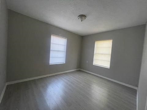 1114 E Pecan St, Angleton, TX 77515 - empty room featuring wood finished floors and a textured ceiling