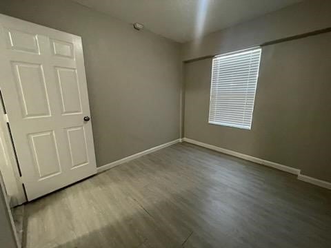 1114 E Pecan St, Angleton, TX 77515 - spare room featuring wood finished floors and baseboards