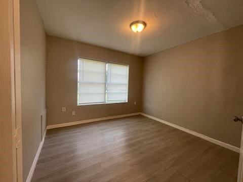 1114 E Pecan St, Angleton, TX 77515 - spare room featuring wood finished floors