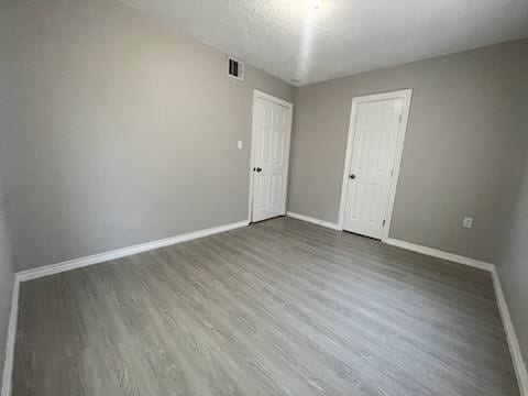 1114 E Pecan St, Angleton, TX 77515 - spare room featuring baseboards and wood finished floors