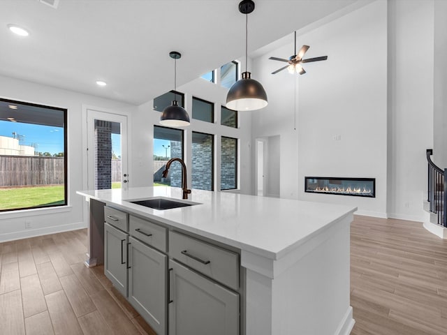 10806 Capella Creek Way, Richmond, TX 77406 - kitchen featuring light wood-type flooring, light countertops, hanging light fixtures, recessed lighting, and a high ceiling