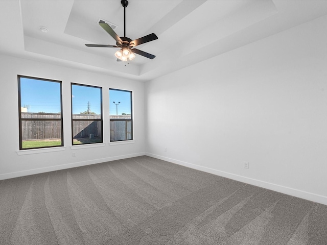 10806 Capella Creek Way, Richmond, TX 77406 - empty room featuring a tray ceiling, dark colored carpet, and a ceiling fan
