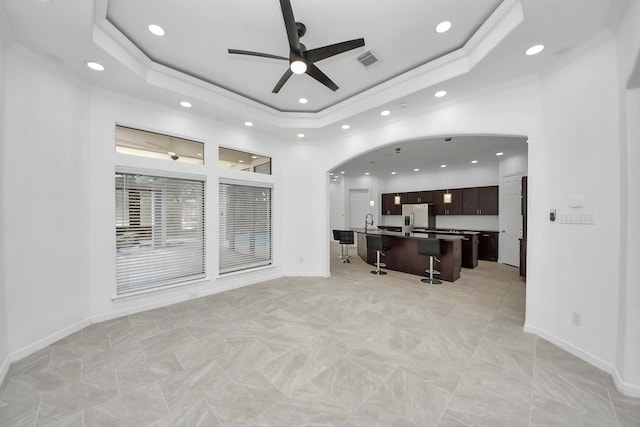 16015 Conners Ace Dr, Spring, TX 77379 - living area with arched walkways, ceiling fan, recessed lighting, a raised ceiling, and a high ceiling