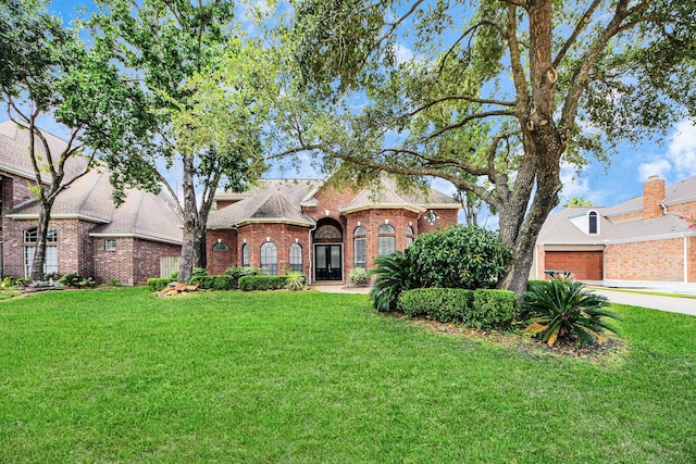 16015 Conners Ace Dr, Spring, TX 77379 - view of front of home featuring a front lawn, a garage, and brick siding
