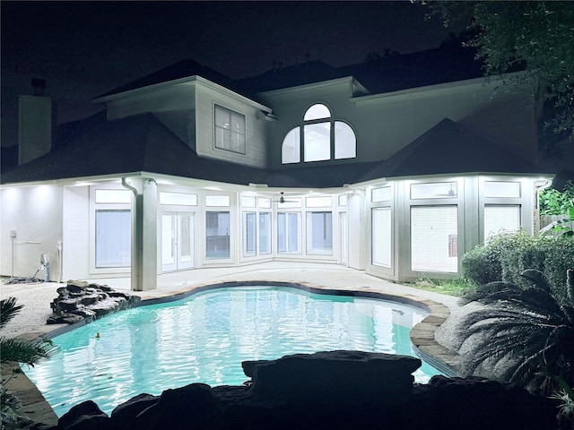 16015 Conners Ace Dr, Spring, TX 77379 - pool at twilight featuring french doors, an outdoor pool, and a patio