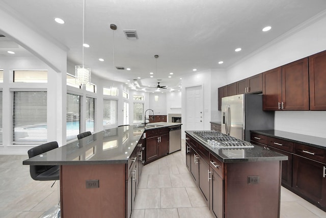 16015 Conners Ace Dr, Spring, TX 77379 - kitchen with a large island with sink, stainless steel appliances, a ceiling fan, a kitchen breakfast bar, and recessed lighting