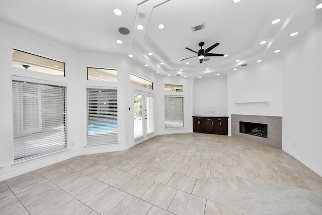16015 Conners Ace Dr, Spring, TX 77379 - unfurnished living room featuring recessed lighting, a tray ceiling, a tile fireplace, light tile patterned floors, and a ceiling fan