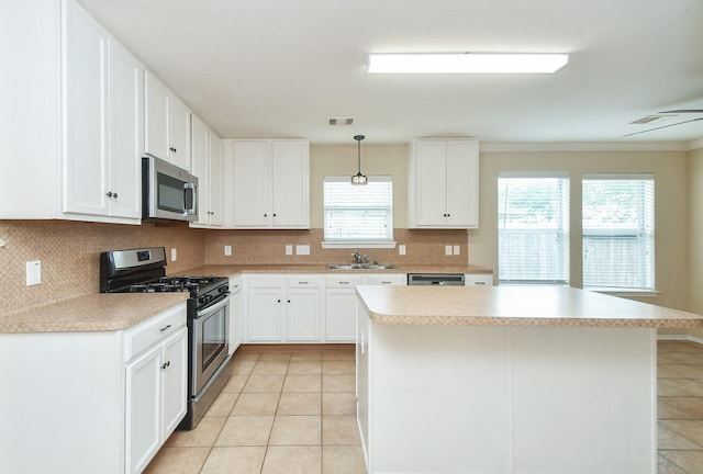 19826 Seagler Glen Ln, Katy, TX 77449 - kitchen featuring appliances with stainless steel finishes, light tile patterned floors, backsplash, light countertops, and a center island