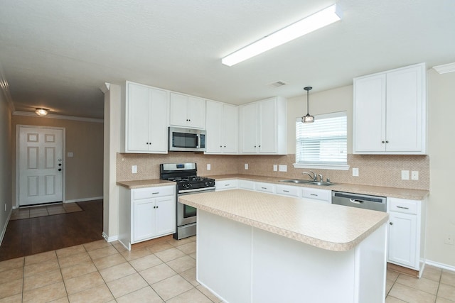 19826 Seagler Glen Ln, Katy, TX 77449 - kitchen with stainless steel appliances, light countertops, decorative backsplash, white cabinets, and crown molding