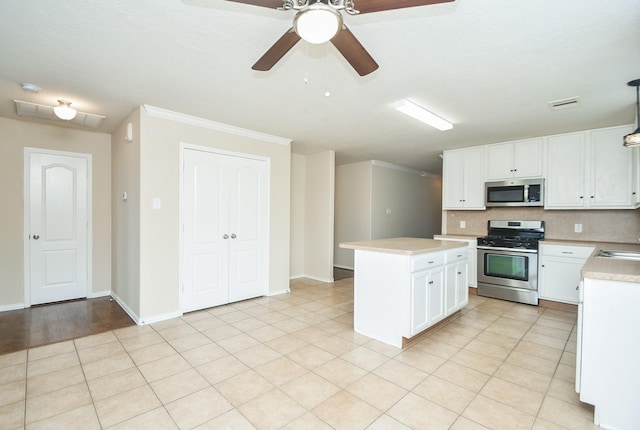 19826 Seagler Glen Ln, Katy, TX 77449 - kitchen featuring appliances with stainless steel finishes, light countertops, a center island, a ceiling fan, and white cabinets