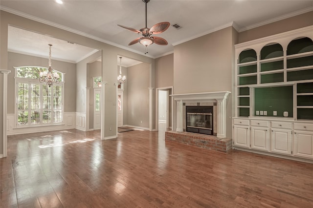426 County Road 222, Nacogdoches, TX 75965 - unfurnished living room featuring a chandelier, a ceiling fan, wood finished floors, a brick fireplace, and wainscoting
