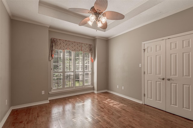 426 County Road 222, Nacogdoches, TX 75965 - empty room featuring a tray ceiling, ceiling fan, wood finished floors, and ornamental molding