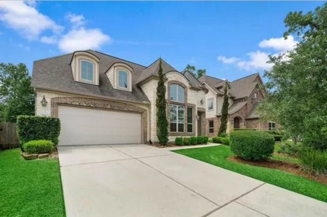 119 Reese Run St, Montgomery, TX 77316 - french provincial home featuring driveway, a front yard, an attached garage, and brick siding