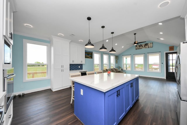 1309 24th St, Dickinson, TX 77539 - kitchen with blue cabinets, white cabinets, a center island, dark wood finished floors, and a ceiling fan