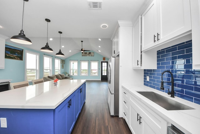1309 24th St, Dickinson, TX 77539 - kitchen featuring freestanding refrigerator, a ceiling fan, dark wood-style flooring, backsplash, and white cabinets