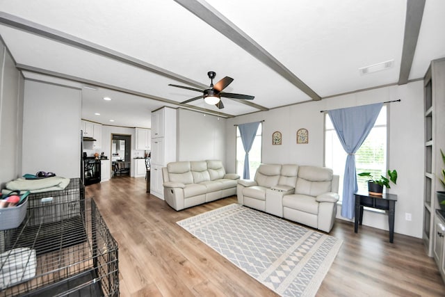 1309 24th St, Dickinson, TX 77539 - living area featuring a ceiling fan, light wood-type flooring, healthy amount of natural light, and beam ceiling