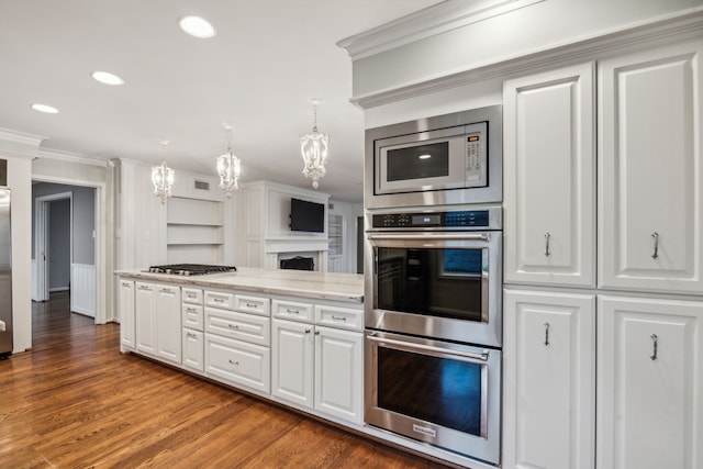 5659 Chevy Chase Dr, Houston, TX 77056 - kitchen with stainless steel appliances, a chandelier, ornamental molding, wood finished floors, and white cabinetry