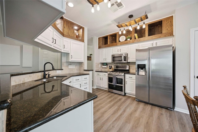 20315 Maple Village Dr, Cypress, TX 77433 - kitchen featuring appliances with stainless steel finishes, white cabinetry, tasteful backsplash, light wood finished floors, and dark stone countertops