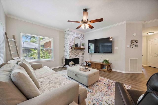 20315 Maple Village Dr, Cypress, TX 77433 - living room featuring wood finished floors, ceiling fan, ornamental molding, and a large fireplace