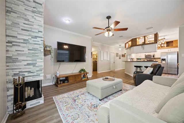 20315 Maple Village Dr, Cypress, TX 77433 - living room featuring ceiling fan, wood finished floors, ornamental molding, and a tile fireplace