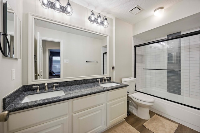 20315 Maple Village Dr, Cypress, TX 77433 - full bath featuring double vanity, shower / bath combination with glass door, wood finished floors, and a textured ceiling