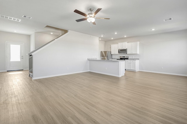 8219 Blooming Meadow Dr, Houston, TX 77016 - unfurnished living room with a ceiling fan, light wood-type flooring, stairs, and recessed lighting
