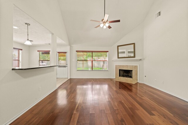 16210 Bloom Meadow Trl, Cypress, TX 77433 - unfurnished living room with a ceiling fan, wood finished floors, high vaulted ceiling, and a tile fireplace