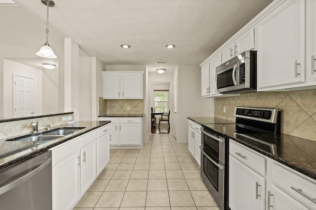 16210 Bloom Meadow Trl, Cypress, TX 77433 - kitchen featuring stainless steel appliances, white cabinets, decorative backsplash, decorative light fixtures, and light tile patterned flooring