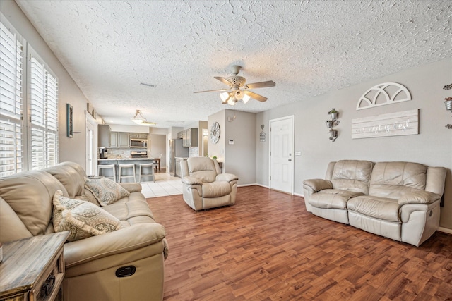 2310 Parkview Dr, Pearland, TX 77581 - living area with ceiling fan, a textured ceiling, and light wood-type flooring