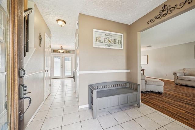2310 Parkview Dr, Pearland, TX 77581 - hallway with a textured ceiling, light tile patterned floors, and french doors