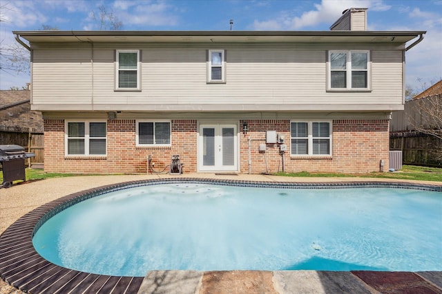 2310 Parkview Dr, Pearland, TX 77581 - back of house featuring french doors, brick siding, an outdoor pool, and a chimney
