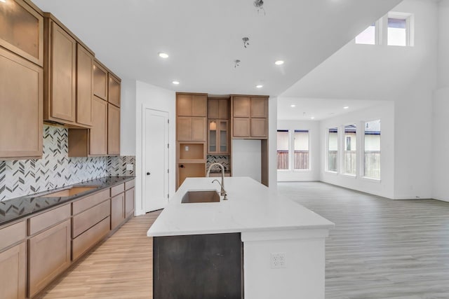 15643 Thirsty Horse Trl, Cypress, TX 77433 - kitchen featuring light wood-style flooring, plenty of natural light, tasteful backsplash, an island with sink, and recessed lighting