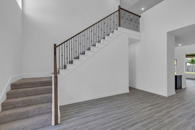 15643 Thirsty Horse Trl, Cypress, TX 77433 - staircase with wood finished floors, a high ceiling, and recessed lighting